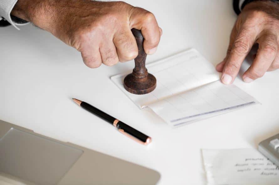 Accountant balancing and approving charges in a checkbook.