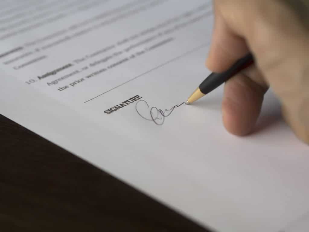 A businessman signs a letter of intent, which is an important part of an acquisition strategy