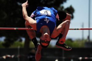 track and field runner jumping a high jump over a pole